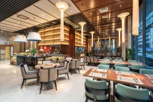 a restaurant with tables and chairs and a bar at H-Vista WestGate Suites in Hanoi