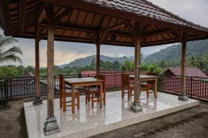 a gazebo with tables and chairs on a balcony at The Kori Homestay in Munduk +32 photos