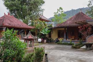 a house with a courtyard in front of it at The Kori Homestay in Munduk