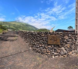 a stone wall with a sign that reads hico at RR Pico in São Mateus