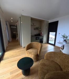 a living room with two chairs and a table at RR Pico in São Mateus +5 photos