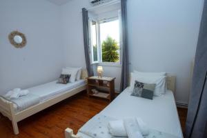 a small room with two beds and a window at Casa Sulla Montagna North Corfu in Loútsai
