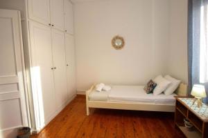 a bedroom with a bed with white walls and wooden floors at Casa Sulla Montagna North Corfu in Loútsai +39 photos