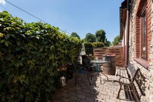 a patio with two chairs and a table next to a building at Pokoje w Starej Karczmie - Free Parking - by Upstairs in Liszki +65 photos