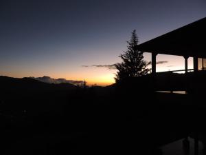 a sunset with a tree and a gazebo at Quinta Galeon Lodge in Santa María