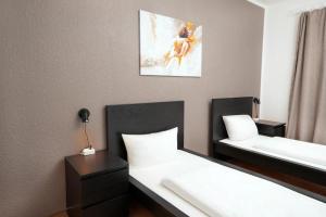 a hotel room with two beds and a mirror at Shin West in Essen