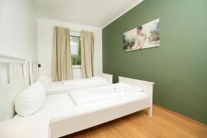 a white room with a white couch and a green wall at Shin West in Essen