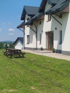 a picnic table in the grass in front of a building at Biała Ostoja 517-539-965 in Berezka