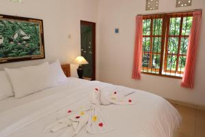a bedroom with a white bed with towels on it at The Kori Homestay in Munduk