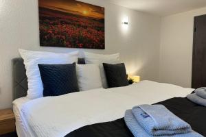 a bedroom with a white bed with a painting on the wall at Relax Apartment Lakewalk in Friedrichshafen