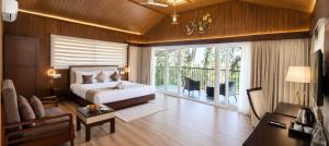 a bedroom with a bed and a living room at Silent Brook Resort - Coorg in Madikeri +70 photos