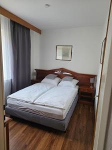 a bedroom with a bed with a wooden headboard at Hotel zur Post in Lüdinghausen