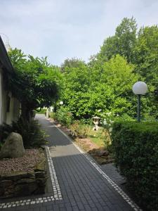 a brick walkway next to a house with trees at Hotel zur Post in Lüdinghausen