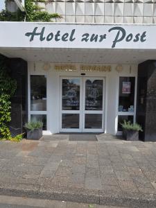 a hotel entrance with the doors of a building at Hotel zur Post in Lüdinghausen +12 photos