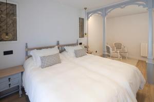 a bedroom with a large white bed with pillows at El Rincón de Julia in Carrión de los Condes