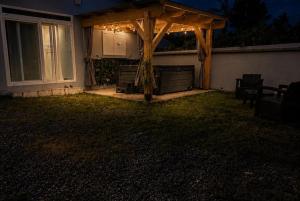 a wooden gazebo in the backyard of a house at night at Villa Cocon Jacuzzi in Saint-Pierre +2 photos