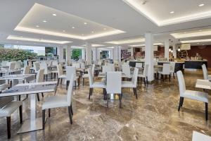 a dining room with white tables and chairs at Hotel Luxor in Playa de Palma