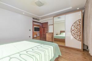 a bedroom with a large bed and a television at Elmoapart in Agadir