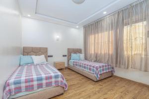 a bedroom with two beds and a window at Elmoapart in Agadir