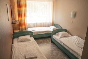a small room with two beds and a window at Minhauzena Unda in Saulkrasti