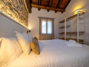 a bedroom with a large white bed with white pillows at mu APARTAMENTOS RURALES in Albella