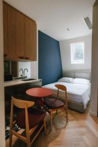 a small room with a bed and a table and chairs at Meidan Heritage Suites Tbilisi in Tbilisi City