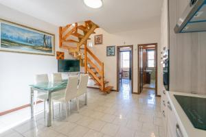 a kitchen and dining room with a table and stairs at Apartment Ampio in Lido degli Estensi