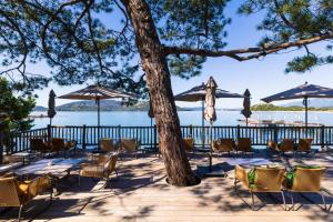 a group of chairs and umbrellas next to the water at Grand Hôtel De Cala Rossa & Spa Nucca in Porto-Vecchio