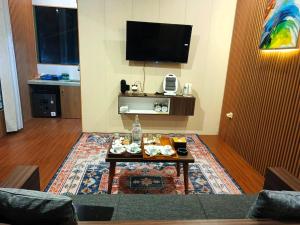 a living room with a coffee table and a flat screen tv at 1440 MDPL Villa & Resort in Wonosobo