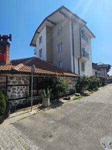 a large house with a stone wall next to a street at Cтаи за гости Бърдареви in Bansko