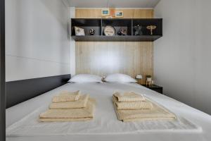 a bedroom with a bed with two towels on it at Mobile Home Altura Luxury Sea View Retreat in Drage