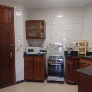 a kitchen with a stove and a microwave at HARMONY GUEST house in Nairobi