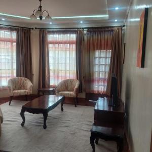 a living room with a coffee table and chairs at HARMONY GUEST house in Nairobi