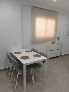 a white table and chairs in a room at Aires de Chipiona Apartamento B in Chipiona