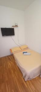 a bed with a book on it in a room at Apartmani Maja in Pag