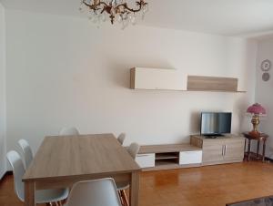 a dining room with a table and a tv at Piso centro de Raxò in Raxó