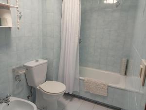 a bathroom with a toilet and a shower and a sink at Piso centro de Raxò in Raxó