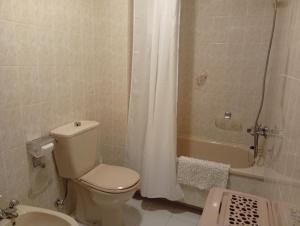 a bathroom with a toilet and a tub and a sink at Piso centro de Raxò in Raxó