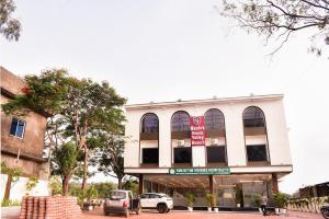 a building with cars parked in front of it at Mandu's Green Valley Resort in Māndu