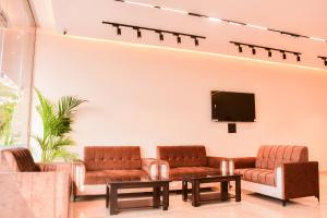 a waiting room with couches and a flat screen tv at Mandu's Green Valley Resort in Māndu +4 photos