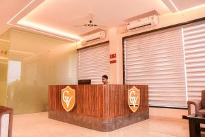 a man is sitting at a desk in a room at Mandu's Green Valley Resort in Māndu