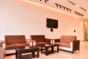 a waiting room with couches and a flat screen tv at Mandu's Green Valley Resort in Māndu