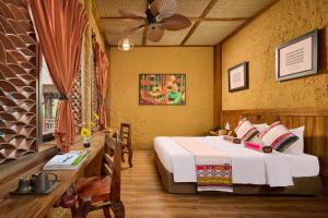 a bedroom with a bed and a table and a fan at Ui Valley Resort in Ninh Binh