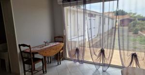 a room with a table and a large window at L'escapade in Rétaud
