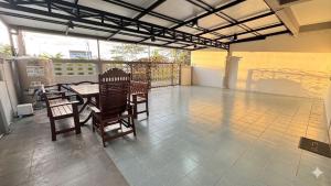 a patio with a table and chairs on a balcony at Triple T House in Hat Yai