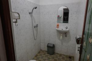 a bathroom with a shower and a sink at The Kori Homestay in Munduk
