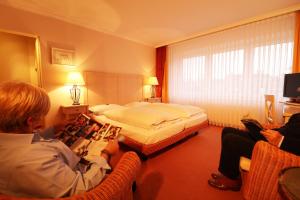 a man reading a magazine in a hotel room at Hotel Central in Zeven