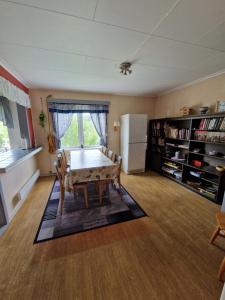 a living room with a table and a refrigerator at Skorovas Fjellstue in Namsskogan