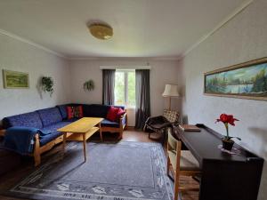 a living room with a blue couch and a table at Skorovas Fjellstue in Namsskogan