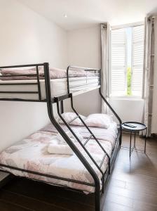a bedroom with two bunk beds and a window at Hôtel Faculté in Marseille